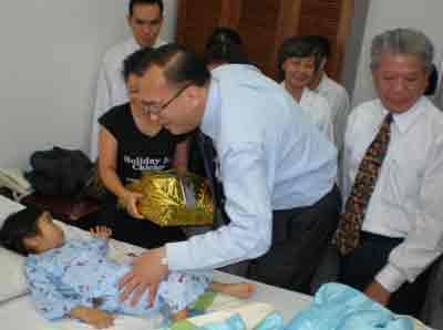 Mr. Tran Thanh Long, SSPP’s president and Mr. Le Thanh An, the US Consul General in HCMC, visit Thanh Van and give her a gift at Tam Duc Hospital in the city on Dec. 8 2010. (Photo: SGGP)