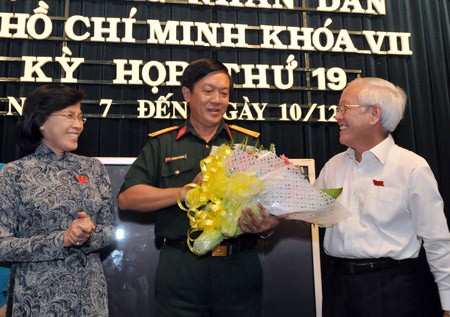 Ms. Pham Phuong Thao, Chairperson of HCMC People's Council (L) and Mr. Le Hoang Quan, HCMC People"s Committee congratulate Mr. Truong Van Hai who was elected as a member of the city People's Committee (Photo: SGGP)