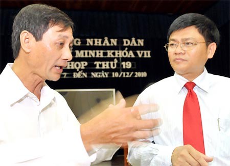 Deputy Dang Van Khoa (L) talks with director of the HCMC Department of Planning and Investment Thai Van Re (R) after the meeting on December 9 (Photo: SGGP)