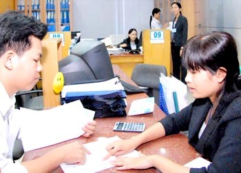A banking staff directs a customer about lending procedures. Banks agree that ceiling interest rates will not be higher than 15% percent a year (Photo: SGGP)