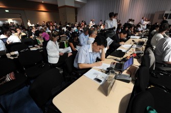 Envoys from more than 190 nations look through documents during the COP16 United Nations Climate Change conference on December 10, 2010 in Cancun, Mexico. AFP