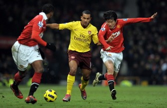 Arsenal's English forward Theo Walcott (C) battles against Manchester United's South Korean midfielder Park Ji-Sung (R) during the match at Old Trafford on December 13, 2010. AFP HOTO/ANDREW YATES --- RESTRICTED TO EDITORIAL USE Additional licence required for any commercial/promotional use or use on TV or internet (except identical online version of newspaper) of Premier League/Football League photos. Tel DataCo
