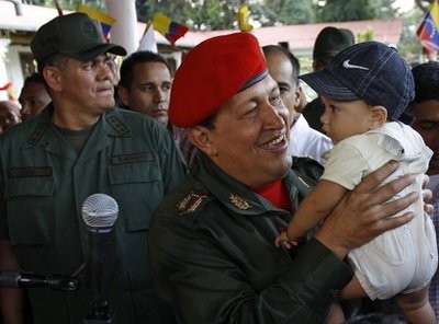Venezuela's President Hugo Chavez carries a baby as he waits for the arrival of Ecuador's President Rafael Correa at the Fort Tiuna military base in Caracas, Venezuela, Tuesday, Dec. 14, 2010.
