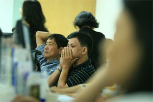 Two investors caustiously watch share prices updated at a HCMC-based brokerage (Photo:Minh Tri)