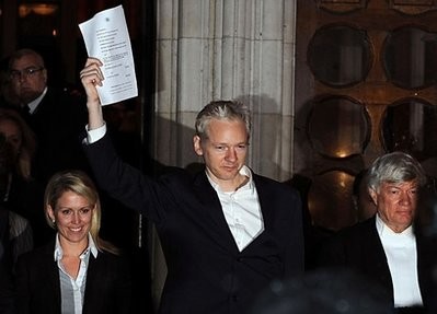 WikiLeaks founder Julian Assange celebrates as he prepares to address the media outside the High Court in central London. AFP