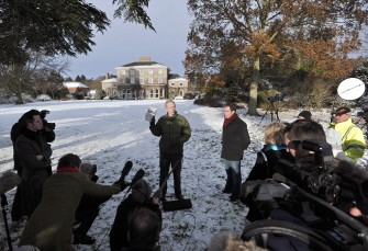 WikiLeaks founder Julian Assange (C) holds up a copy of Britain's Guardian newspaper as he addreses media in the grounds of Ellingham Hall in Norfolk, eastern England, on December 17, 2010.