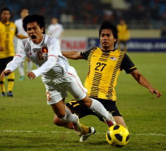 Vietnam striker Nguyen Quang Hai (L) fights for the ball with Malaysia defender Mohamad Fadhli Bin Mohd Shas during Saturday’s the second-leg semifinal in Hanoi. AFP