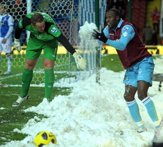 Blackburn's English goalkeeper Paul Robinson (L) plays in the snow with West Ham United's English striker Carlton Cole (R) during the English Premier League football match between Blackburn Rovers and West Ham United at Ewood Park in Blackburn on December 18, 2010. AFP