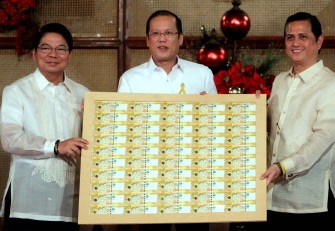 (AFP) Handout photo taken on December 16, 2010 and received from the Malacanang Photo Bureau (MPB) on December 18 shows Philippine President Benigno Aquino (C), Governor and Monetary Board Chairman Amando Tetangco Jr (L), and National Treasurer Roberto Tan displaying the new 500 peso notes.