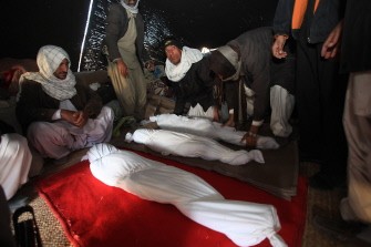 Iranian men gather around the bodies of victims killed in the earthquake. AFP