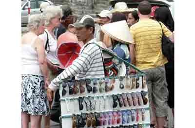 Street vendors insistently invite foreign tourists to buy items at Cau Da Port in the City Nha Trang in the central province of Khanh Hoa.The province will forbid street vendors to annoy tourists at historical and cultural sites (Photo: Tuoitre)