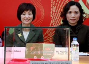 Vietnamobile CEO Elizabete Fong (L) introduces the gold Sim weighing 1kg plus in Hanoi on Dec. 20, 2010 (Photo: Thuy Hoa)
