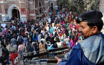AFP - A Pakistani policeman stands guard as Christian attend the Christmas service at the Saint Anthony s Church in Lahore on December 25, 2010.