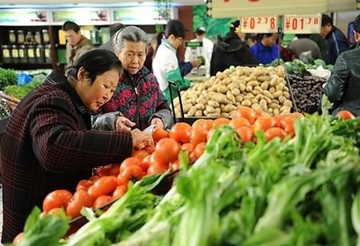 Chinese customers buy vegetables at a supermarket in Hefei, east China's Anhui province on December 23