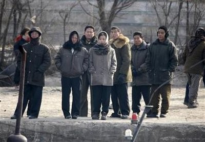 North Koreans stand on the banks of the Yalu River near the North Korean town of Sinuiju, opposite the Chinese border city of Dandong, December 26, 2010