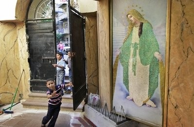 In this Tuesday, July 20, 2010 file photo, children run past a painting of the Virgin Mary inside the entrance of the Virgin Mary Coptic church in the el-Asafra area of the coastal city of Alexandria, Egypt.
