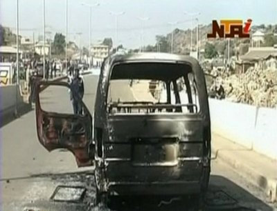 In this image made from video provided NTA via APTN, and taken Saturday, Dec. 25, 2010, a burned out van is seen on a road following violence in Jos, Nigeria.