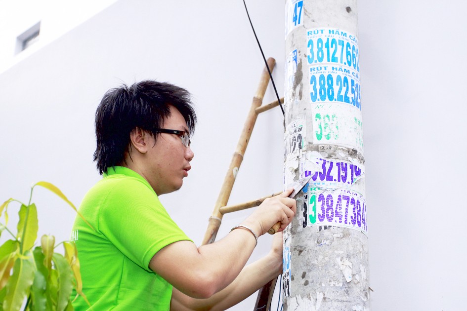A volunteer cleans lamp post.