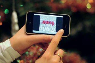 A person holds up a holiday card on her iphone on December 30, 2010 in Paris. AFP