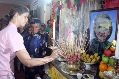 Bà Joanne Luke, chuyên gia người Úc của Hội Trợ giúp người tàn tật Việt Nam, thắp hương phúng viếng mẹ Thứ. Ảnh: N. KHÔI