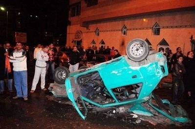 Egyptians inspect a car bomb following an attack on a Christian church in the Egyptian port city of Alexandria on January 1, 2011. AFP