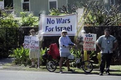 Protesters hold signs supporting Palestine as U.S. President Barack Obama's motorcade leaves the compound where he and his family are staying while on Christmas vacation in Hawaii in Kailua, Hawaii January 1, 2011.