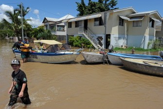 Road signs are used to moor boats after the Fitzroy River broke its banks and inundated much of Rockhampton on January 4, 2011. AFP