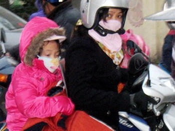 A primary class student (in pink) braves the cold to go to school in Hanoi (Photo: VNA)