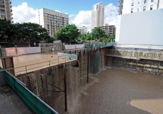 Water cascades into a building site as flood waters inundate Brisbane on January 13, 2011. AFP