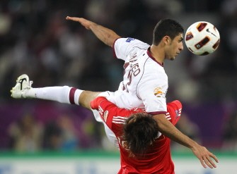 Qatar's defender Ibrahim Majed (top) jumps over China's midfielder Deng Zhuoxiang to head the ball during the game. AFP