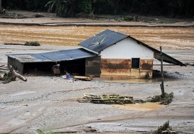 A man carries belonging from the only house not swept away by water after heavy rains in the village of Vieira, 40 km from Teresopolis