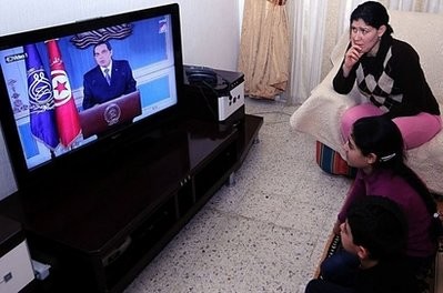 A Tunisian family watches as President Zine El Abidine Ben Ali gives a speech