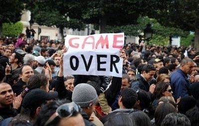 A demonstrator holds a placard reading Game Over during a rally in front of the Interior Ministry in Tunis.