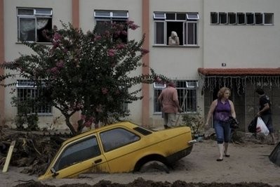 A car is encased in sand amid a flood-hit street in Nova Friburgo, Rio de Janeiro on January 16, 2011