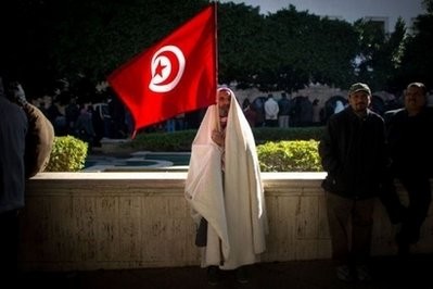 AFP - A man is seen holding a Tunisian national flag during a demonstration, in central Tunis.