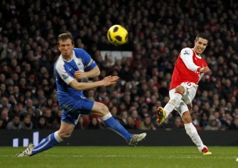 Robin Van Persie shoots past Wigan's Scottish defender Gary Caldwell (L) during the match on January 22, 2011. AFP