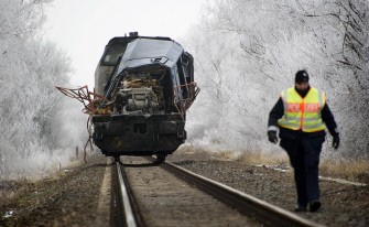 A police officer walks along the railway track in front of the collision damaged locomotive of the freight train at the scene of the accident. AFP