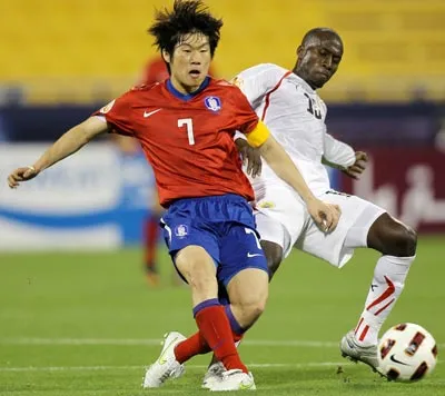 Đội trưởng Park Ji Sung (số 7 - Hàn Quốc) trước sự truy cản của tiền vệ Abdullah Omar (Bharain).