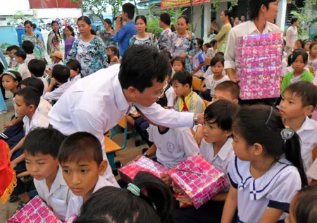 Lãnh đạo chính quyền địa phương trao quà cho các em học sinh có hoàn cảnh khó khăn. Ảnh: HỒ VIỆT