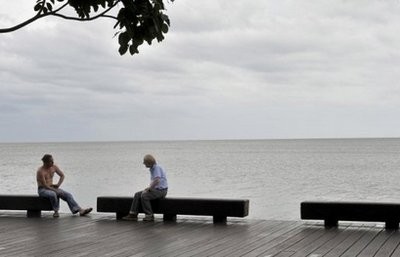 Locals chat casually on the Esplanade in Cairns as storm clouds gather over the Coral Sea ahead of the impending cyclone Yasi, on February 2.