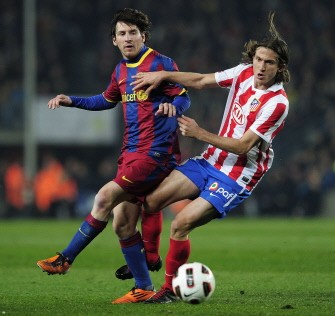 Lionel Messi (L) vies with Atletico Madrid's defender Filipe (R) during the match Barcelona vs Atletico de Madrid on February 5, 2011. AFP