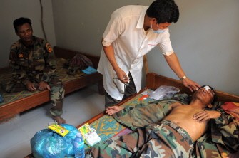 A Cambodian doctor checks a wounded soldier at a military hospital after fighting on February 4 to 7 at the Preah Vihear temple. AFP