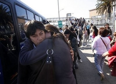 AFP - A couple hug as people evacuate buildings and gather on the streets in Concepcion, south of Santiago.