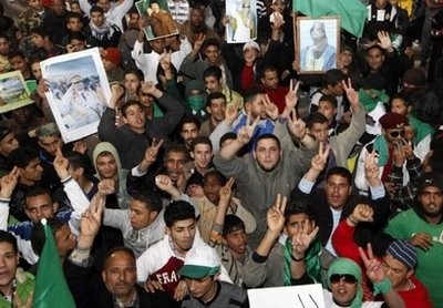 Supporters of Libyan leader Moamer Kadhafi hold his picture during a pro-government rally in Tripoli