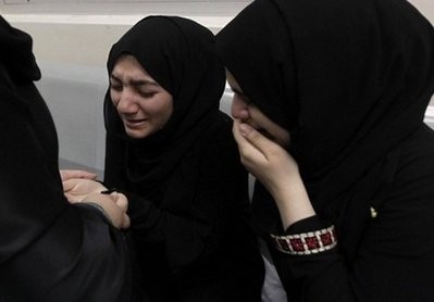 Bahraini women cry at a hospital where wounded anti-regime protesters were brought after police opened fire on them in Manama