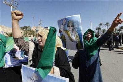 Pro-government supporters hold posters of Libyan leader Muammar Gaddafi as they chant slogans during a demonstration in Tripoli February 17, 2011.