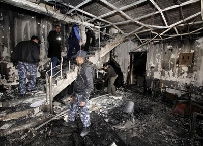 Security forces inspect a destroyed television station in Sulaimaniyah, 260 kilometers (160 miles) northeast of Baghdad, Iraq, Sunday, Feb. 20, 2011