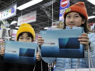 AFP - Two young customers hold up Nintendo's new video game console 3DS after buying it on the first day of release at a Tokyo computer shop on Feb 26, 2011