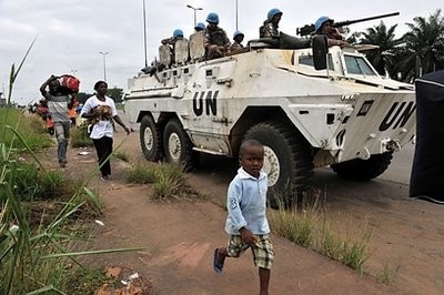 Inhabitants of the Abobo district in Abidjan flee the area past a United Nations armoured vehicle following fresh clashes between forces loyal to rival claimants for the presidency on February 27. AFP