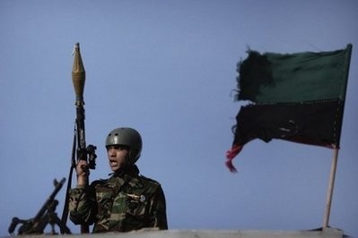 A rebel Libyan soldier holds a rocket-propelled grenade launcher as he stands on the roof of a barracks in Benghazi.